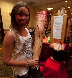 Hannah DuBois from Cherry Hill, N.J., shows off a leg made by her father, Brian Dubois, a special effects artist. Their stall has every body part you can imagine for sale, including a headless and limbless torso.