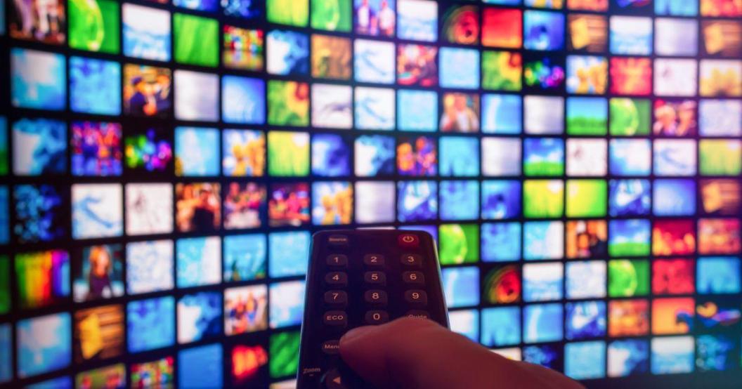 Video on demand screen with remote control in hand