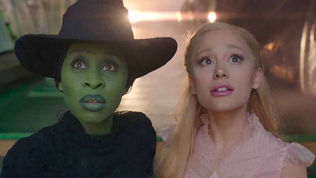 Cynthia Erivo and Ariana Grande stand side-by-side in Wicked.