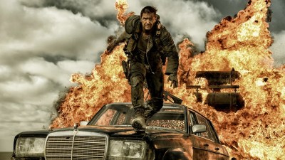Tom Hardy as Mad Max jumping away from an exploding car in Mad Max: Fury Road