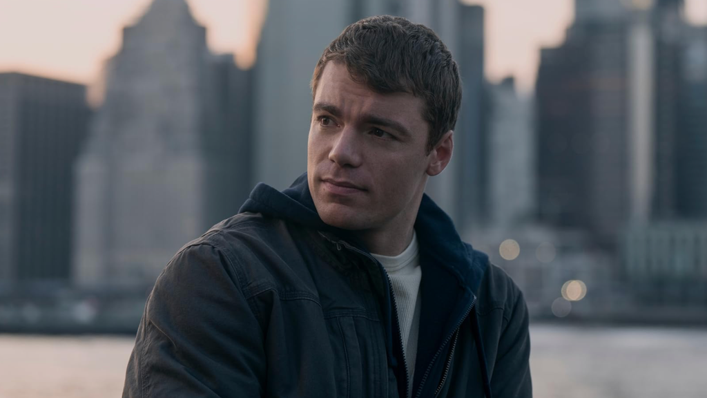 Gabriel Basso gazing into the distance wearing a gray jacket in The Night Agent.