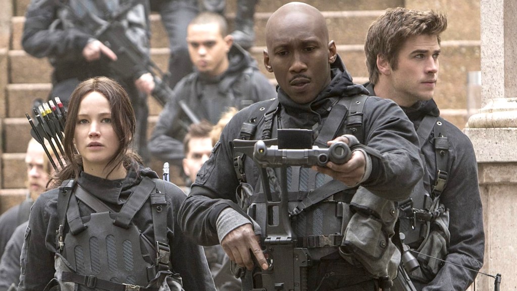 Jennifer Lawrence como Katniss, Mahershala Ali como Boggs y Liam Hemsworth como Gale en los Juegos del Hambre: Mockingjay Parte 2