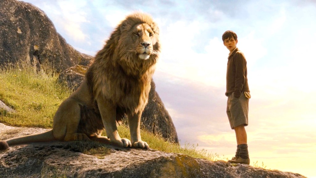 Skandar Keynes como Edmund de pie junto a Aslan the Lion en las Crónicas de Narnia: el león, la bruja y el armario