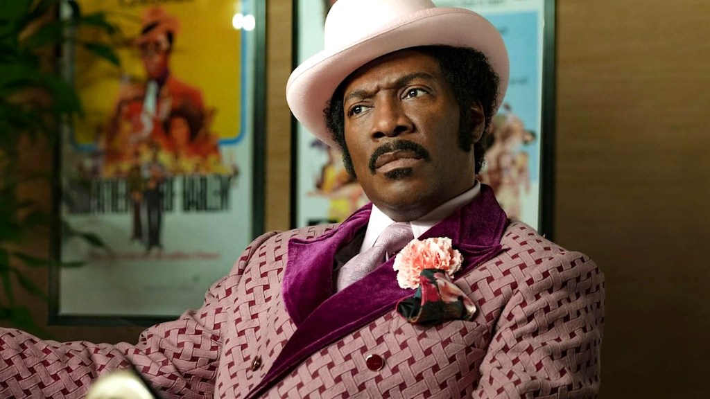 Eddie Murphy wearing pink suit with pink flower and hat in Dolemite Is My Name