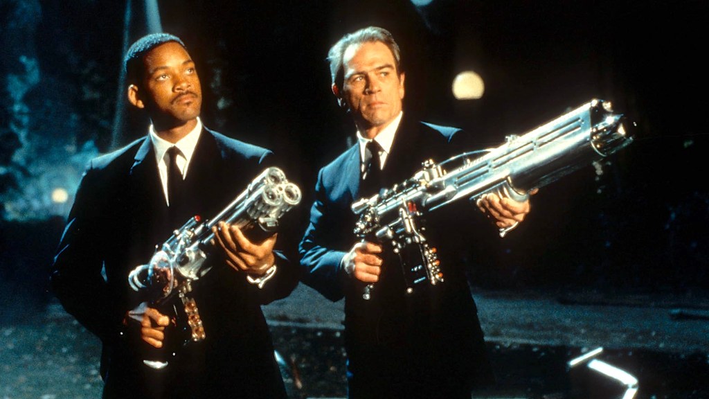 Will Smith and Tommy Lee Jones holding huge guns and wearing suits in Men in Black