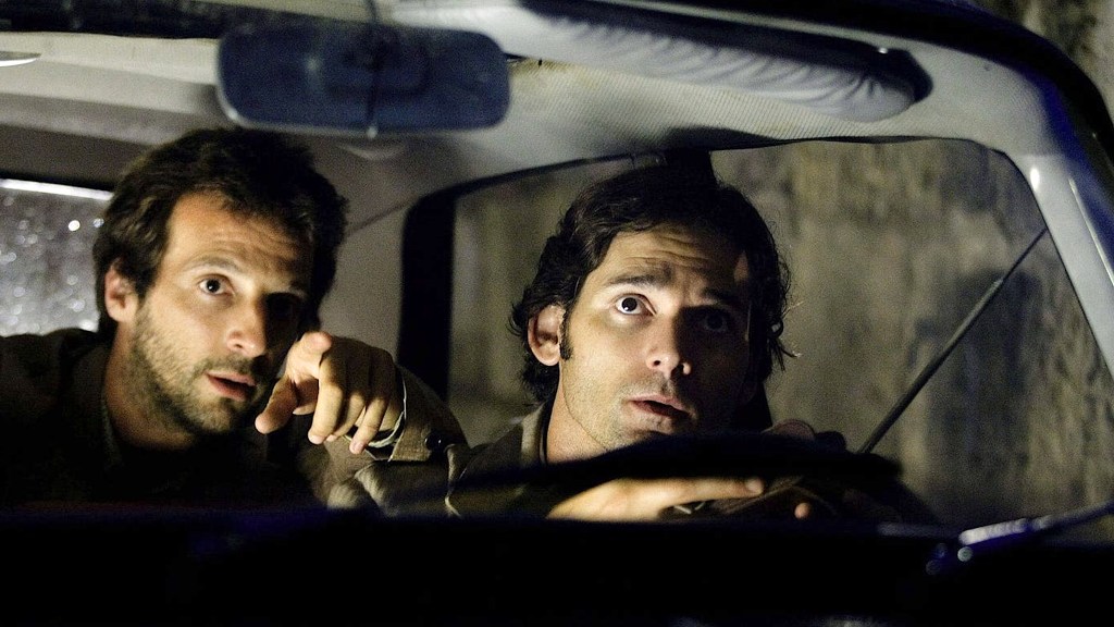 Mathieu Kassovitz and Eric Bana sitting in a dark car in Munich