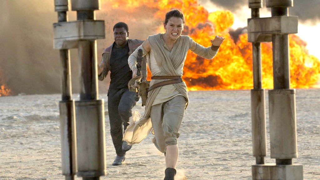 John Boyega en el papel de Finn y Daisy Ridley mientras Rey huye de la explosión en Star Wars: The Force Awakens