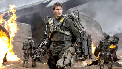 Tom Cruise wearing mech suit with fires around him in Edge of Tomorrow