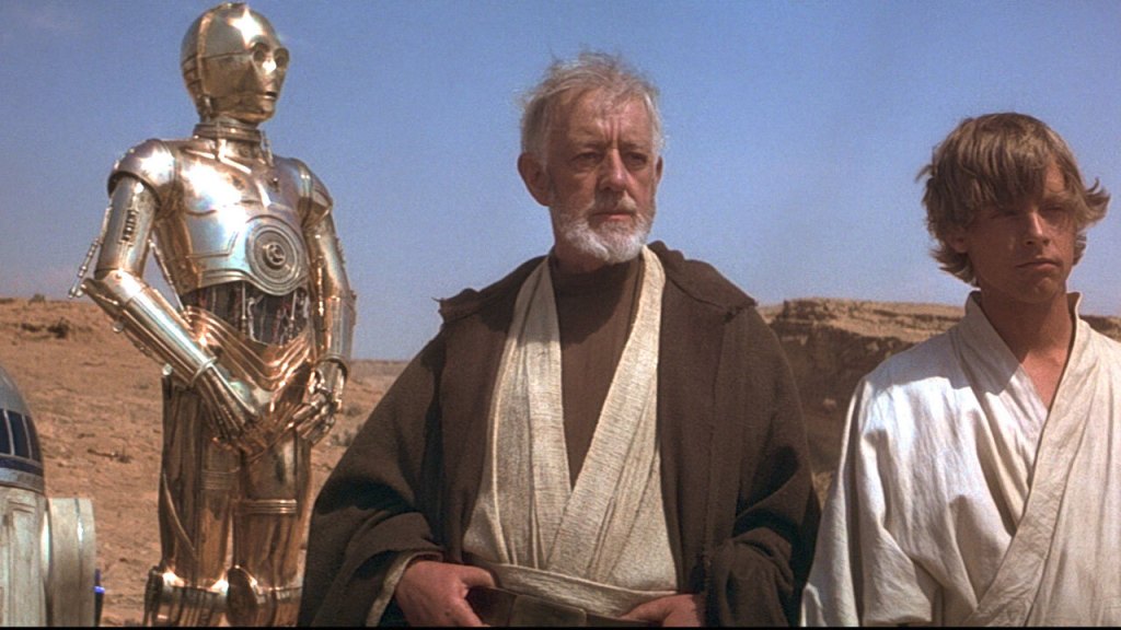 Obi-Wan Kenobi standing with C-3PO and Luke Skywalker on Tattooine in Star Wars: Episode IV: A New Hope