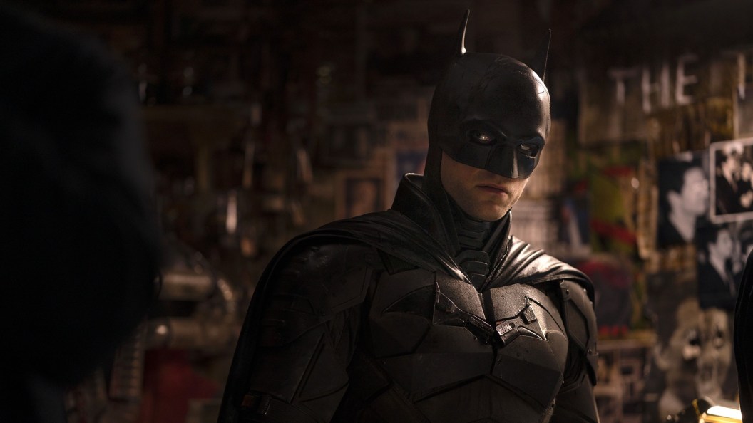 Robert Pattinson as Batman standing in Riddler's apartment