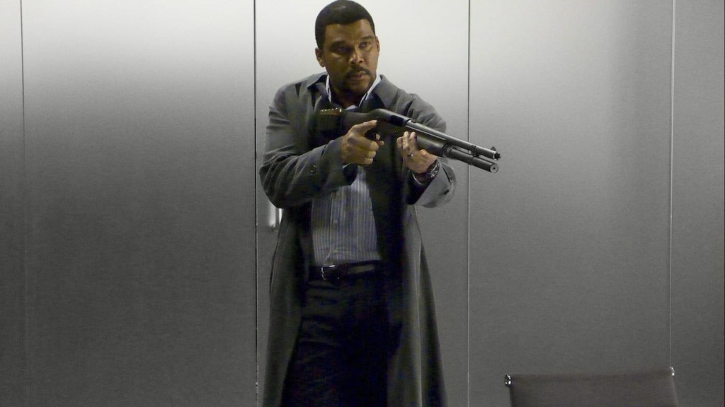 Tyler Perry holds a gun in Alex Cross