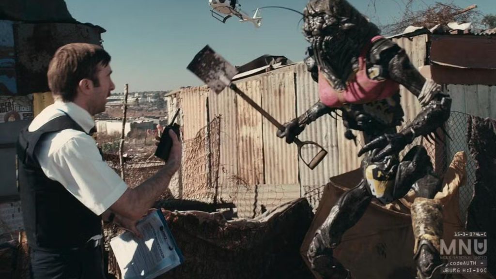 Sharlto Copley as Wikus van der Merwe in District 9