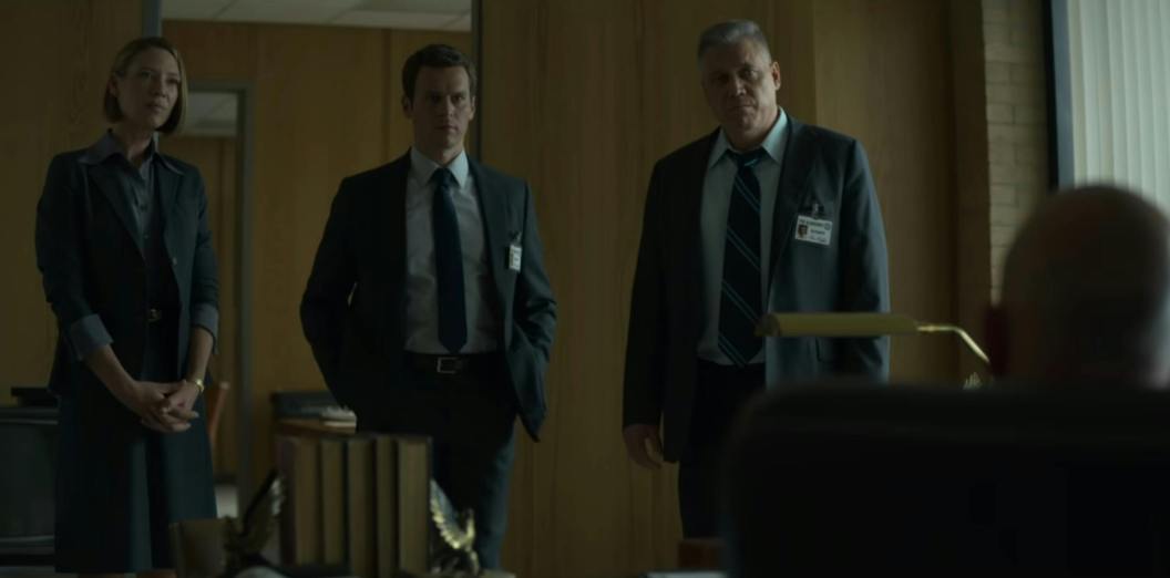 Ford, Carr, and Tench chat in the office