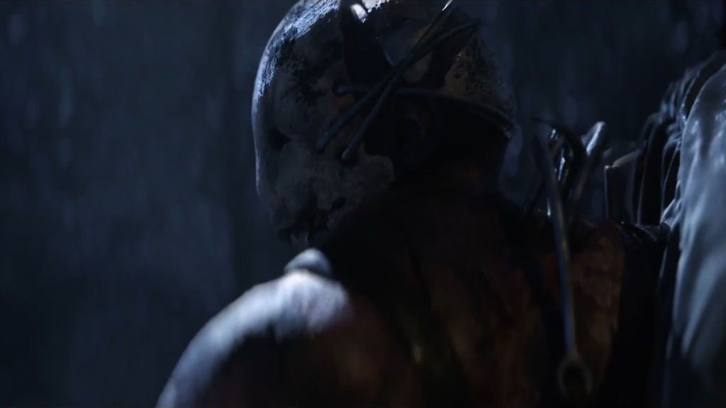 Shoulder shot of the Trapper looking behind him while carrying a body