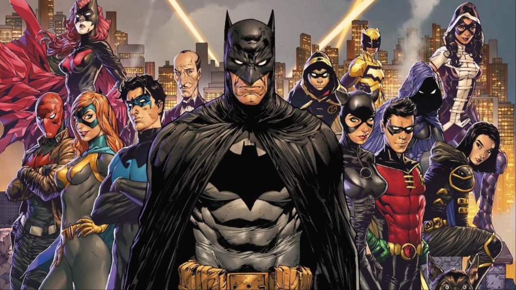 Batwoman, Red Hood, Barbara Gordon, Nightwing, Alfred, Batman, Catwoman, Damian Wayne, Huntress, Spoiler, Orphan, and the Signal all standing together on a Gotham rooftop