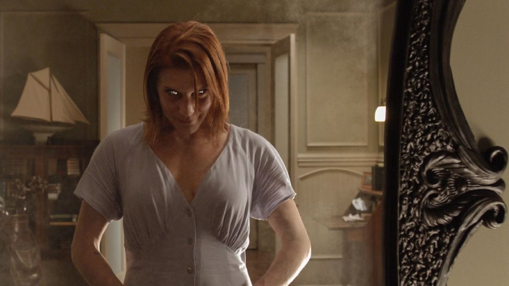Uma mulher olhando fixamente para um espelho em Oculus (2013)