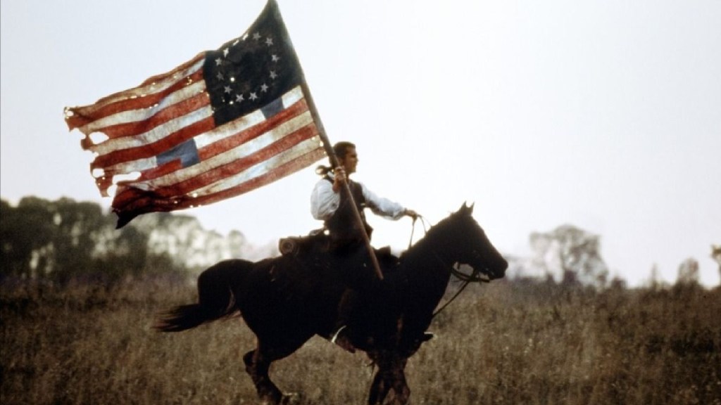 Mel Gibson riding a horse and brandishing a flag in The Patriot (2000)