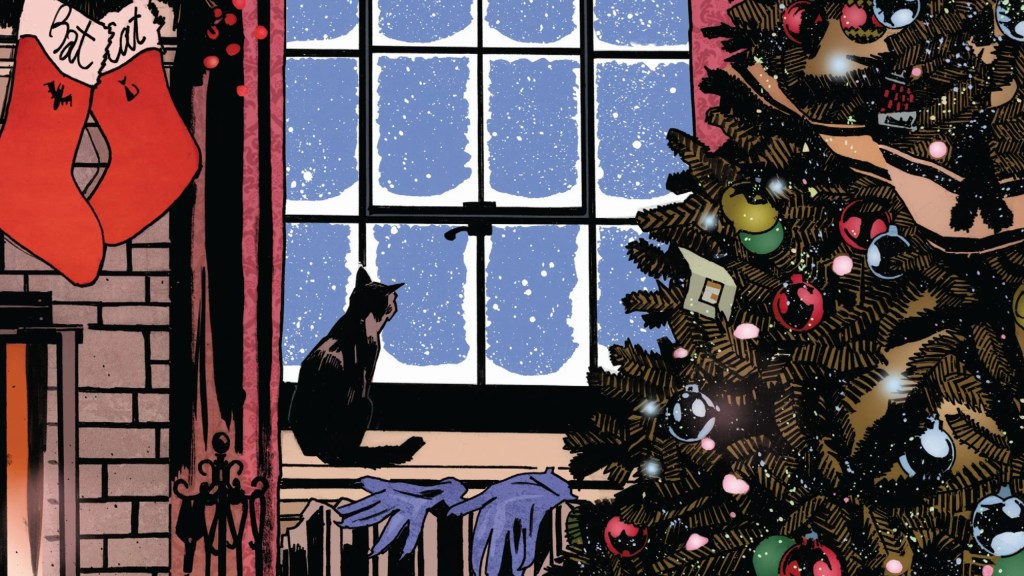 A cat sitting on a window sill with snow outside in a room decorated for Christmas