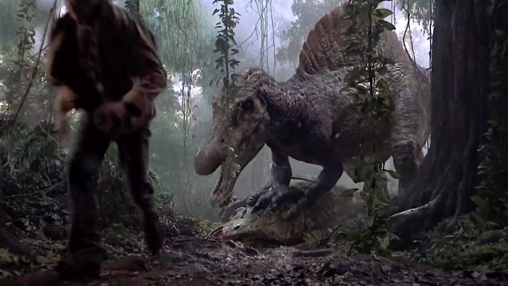 A Spinosaurus crouching over the body of a Tyrannosaurus while Alan Grant runs away in Jurassic Park III