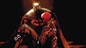 Batman cradling an unconscious Red Hood