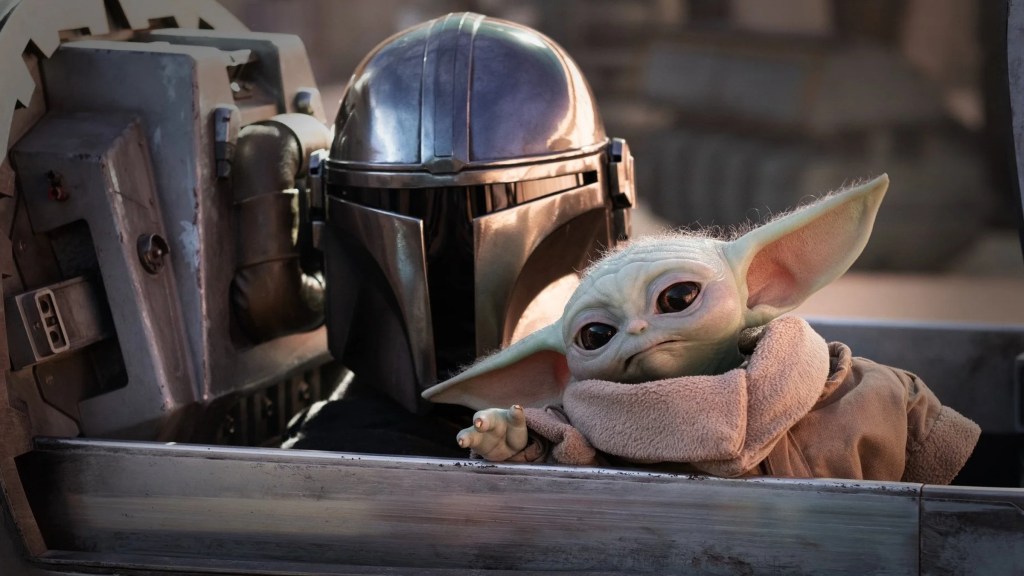 Pedro Pascal as Djin Djarin with Grogu in The Mandalorian
