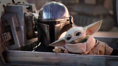 Pedro Pascal as Djin Djarin with Grogu in The Mandalorian