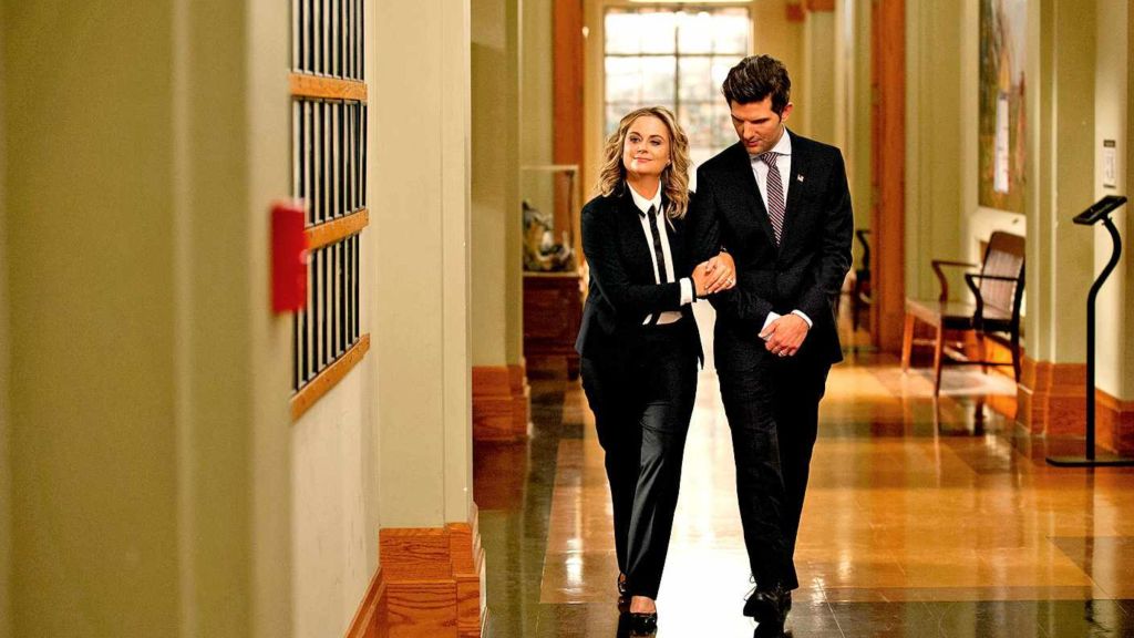 Leslie and Ben walking down a hallway in Parks and Rec.