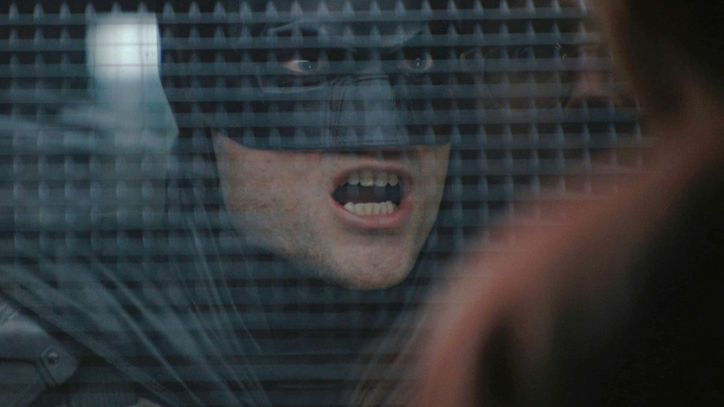 Batman yelling at the Riddler inside Arkham in The Batman