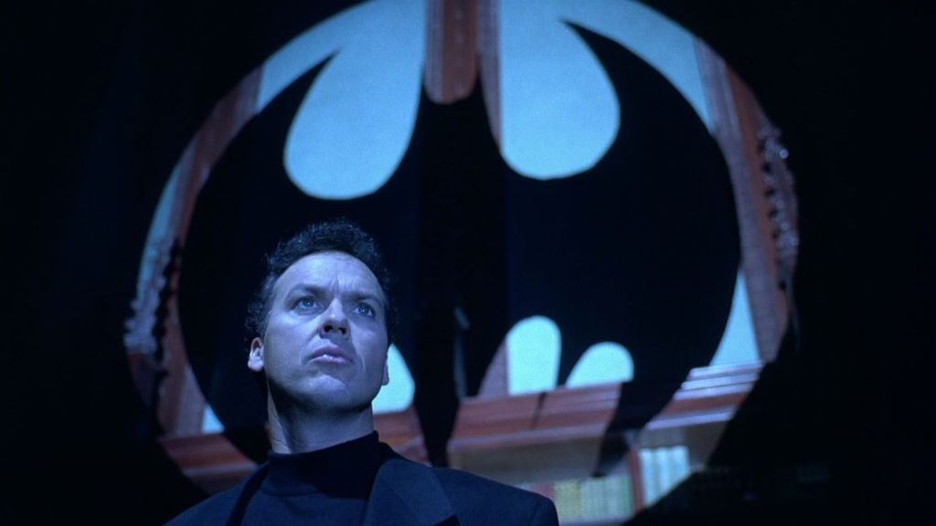 Bruce Wayne with the bat symbol behind him in Batman Returns
