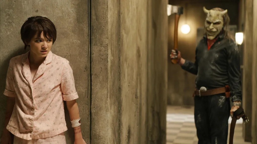 Madeleine McGraw as Gwen hiding from Ethan Hawke as the Grabber in The Black Phone 2