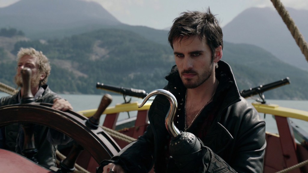 Captain Hook looking serious standing in a boat in Once Upon a Time