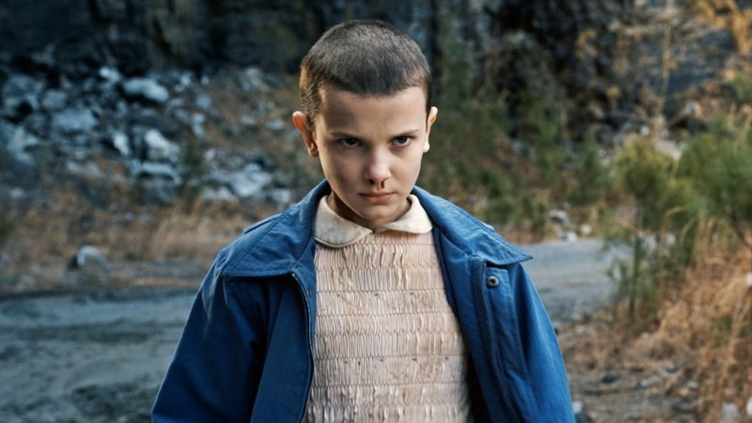 Millie Bobby Brown as Eleven looking angry and having a nosebleed in Stranger Things Season 1