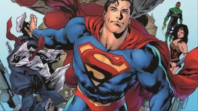 Superman throwing aside Clark Kent's suit in front of the Daily Planet building with the Justice League behind him