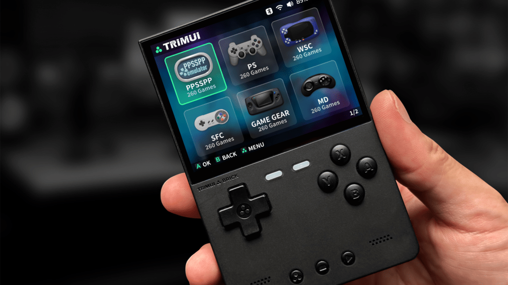 A TRIMUI Brick being held in a person's hand, showing icons on its screen.