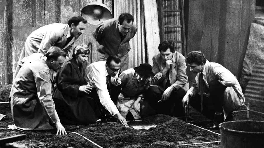 A group of men gathered around in Quatermass and the Pit (1958)