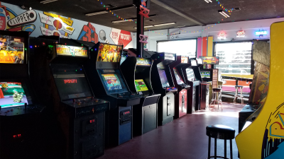 A photo of the Retrovolt Arcade taken in 2017, showing several classic arcade cabinets and stools.