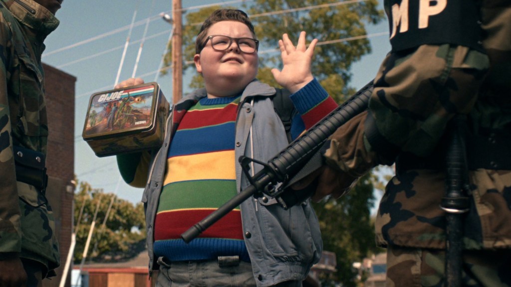 Derek Turnbow putting up his hands in front of soldiers in Stranger Things Season 5