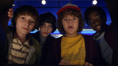 Will, Mike, Dustin, and Lucas looking down at something in Stranger Things Season 2