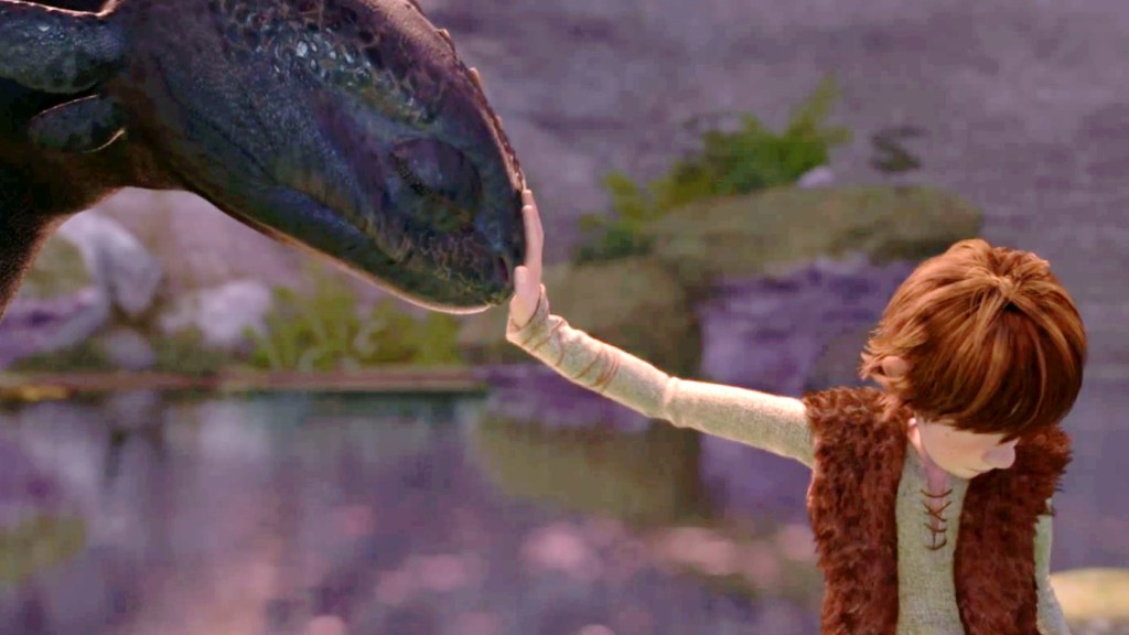 Hiccup touching Toothless' snout and looking away in How to Train Your Dragon