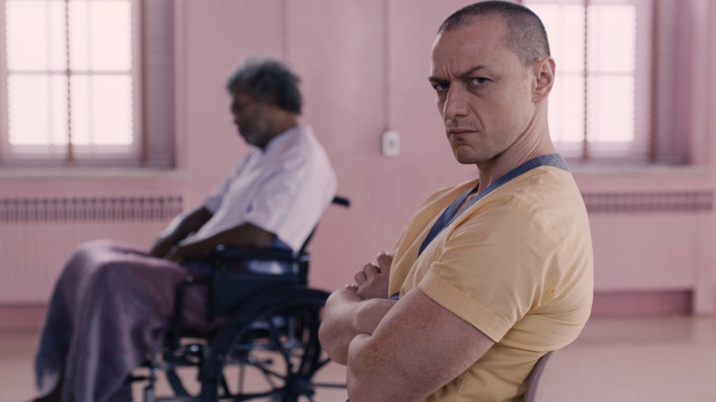 James McAvoy as Kevin Wendell Crumb looking annoyed at the camera with Samuel L. Jackson's Elijah in the background in Glass
