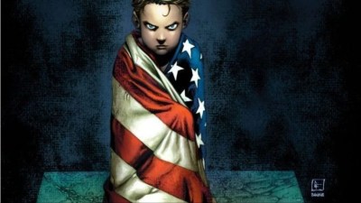 A young boy wrapped in an American flag