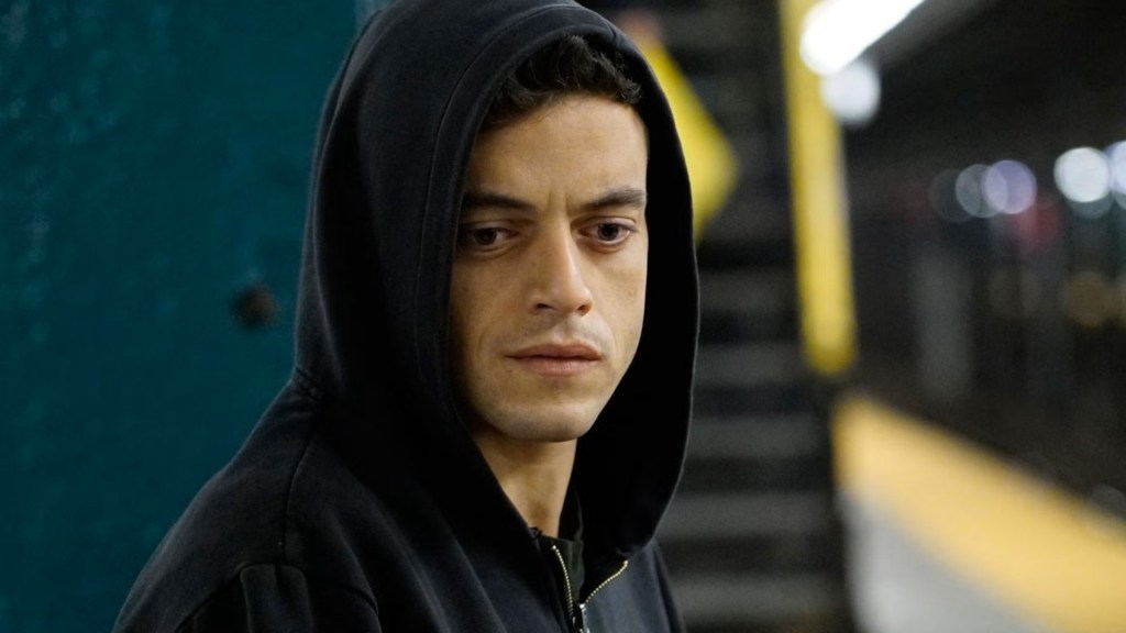 Rami Malek as Elliot Alderson wearing a black sweatshirt with his hood up in Mr. Robot