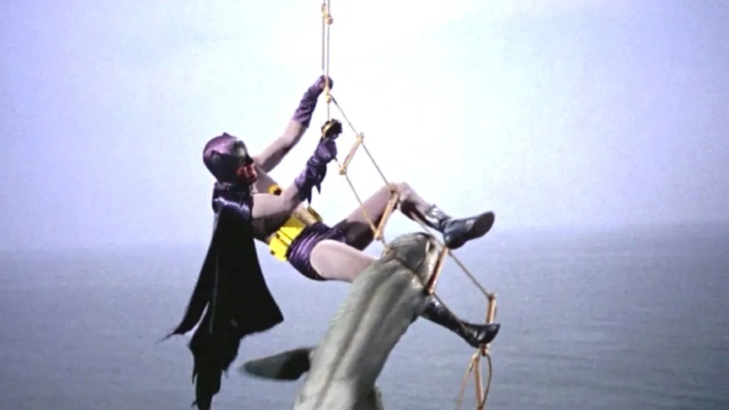 Batman on a rope ladder escaping a shark in Batman (1966)