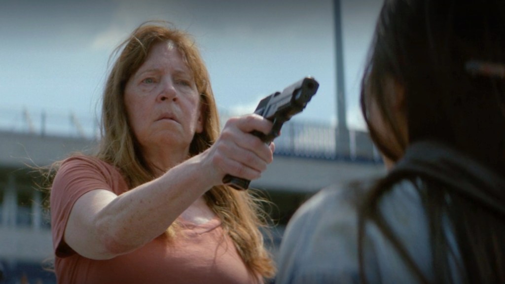 Aunt Lydia holding a gun in The Testaments