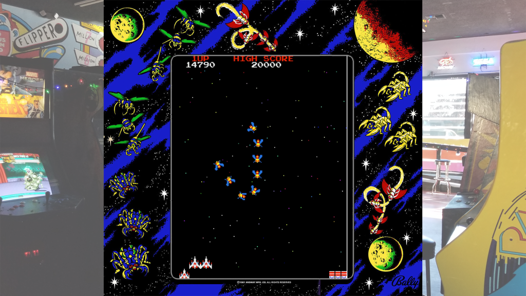 A screenshot from Galaga with arcade bezel art over a picture of Retrovolt Arcade.