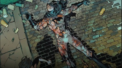 A beaten Batman laying on the pavement