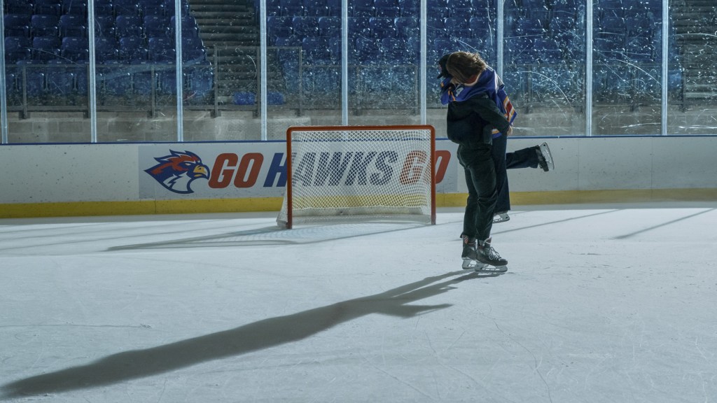 Garrett and Hannah embracing on the hockey rink in Off Campus