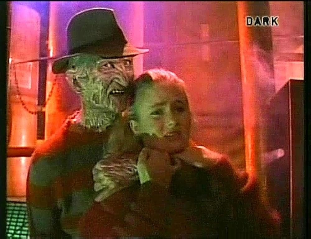 Freddy Krueger holds a distressed-looking girl.