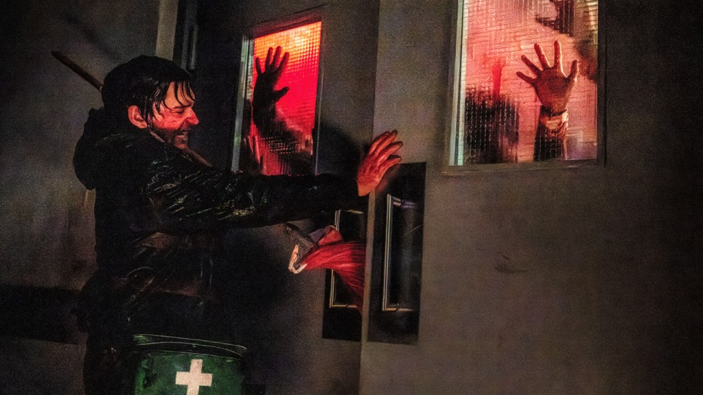 Austin Abrams as Bryan in Zach Cregger's Resident Evil, closing a bloody door to escape zombies