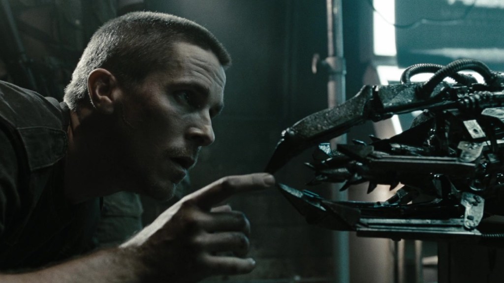 John Connor touching a machine part in Terminator Salvation